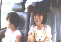 移動のバスの中で泣く少女